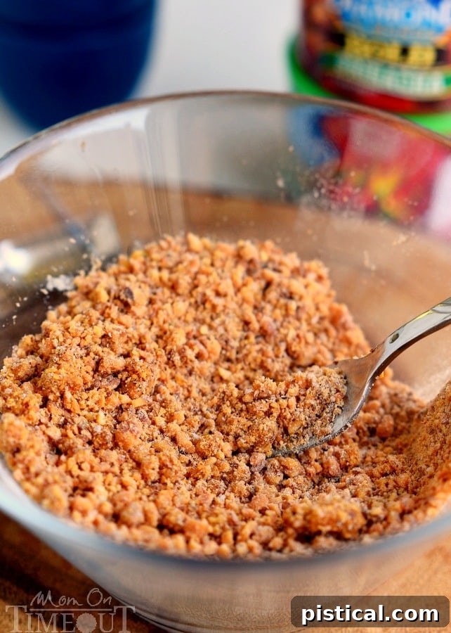 Close-up of the dry mixture for chicken strips, showing finely chopped Sriracha almonds, flour, and spices combined in a clear bowl.