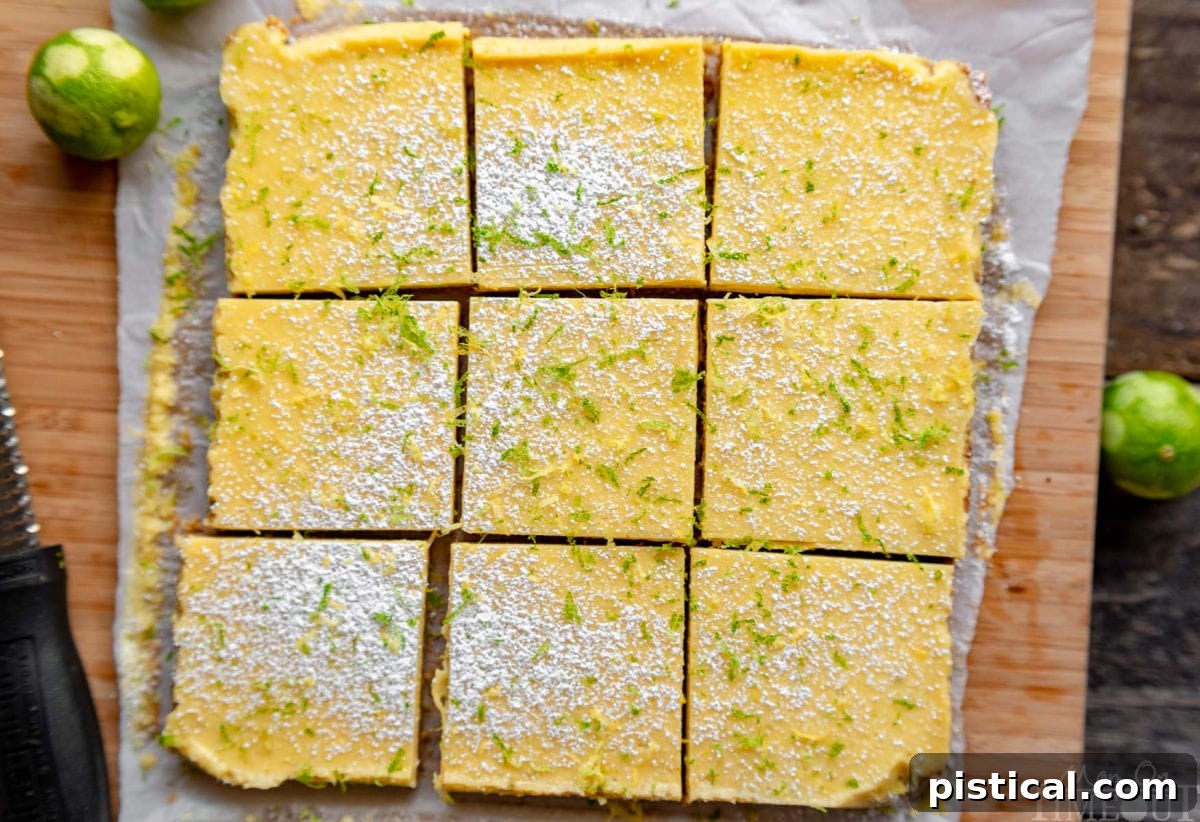 Zesty Key Lime Squares 4 A top-down view of nine perfectly cut Key Lime Pie Bars arranged in neat squares on a rustic cutting board, ready to be served.