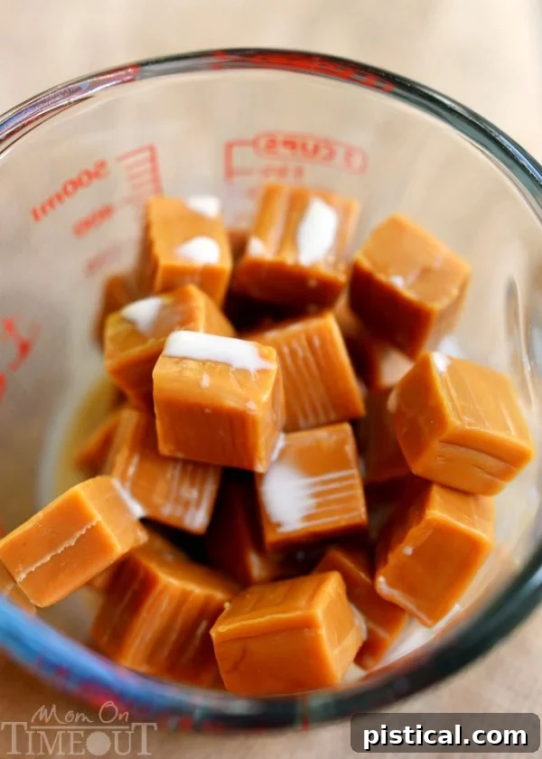 Unwrapped caramels and evaporated milk melting in a glass measuring cup in the microwave, creating a smooth caramel sauce for Carmelitas.