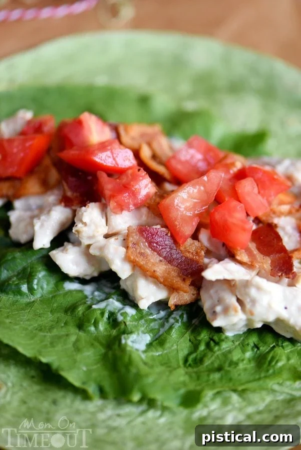 Close-up of a delicious BLT Chicken Caesar Salad Wrap, showcasing the fresh ingredients like chicken, bacon, lettuce, and tomato in a soft tortilla. | MomOnTimeout.com | #recipe #ad
