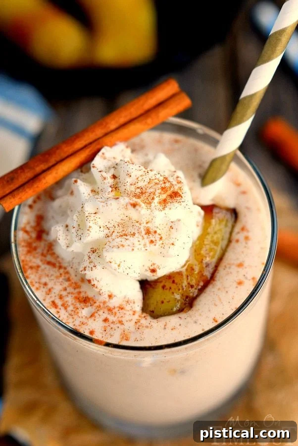 Two glasses of Bananas Foster Smoothie, topped with whipped cream and a sprinkle of cinnamon, ready to enjoy.