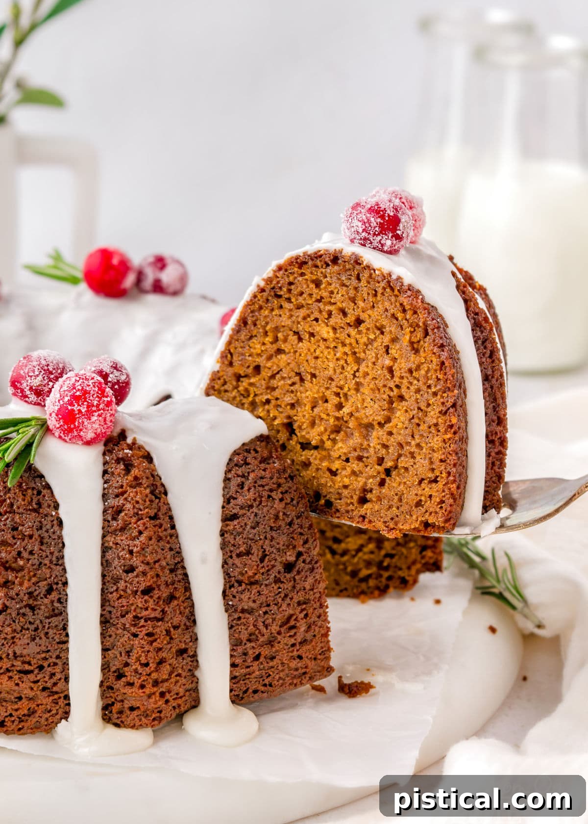 Cozy Gingerbread Bundt Delight 6 A spatula lifting a generous piece of gingerbread bundt cake, showcasing its moist texture and perfect icing, above the remaining cake.