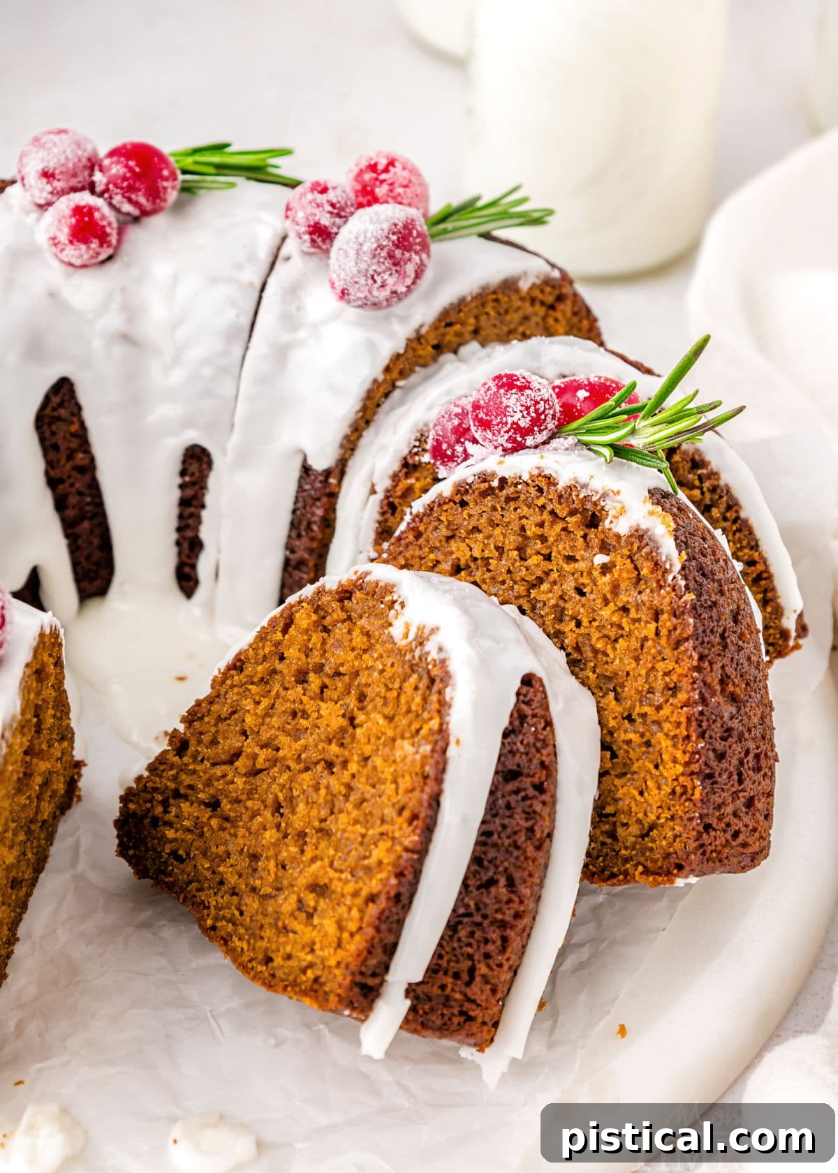 Cozy Gingerbread Bundt Delight 7 A beautifully sliced gingerbread bundt cake on a white cake stand, inviting you to take a piece.