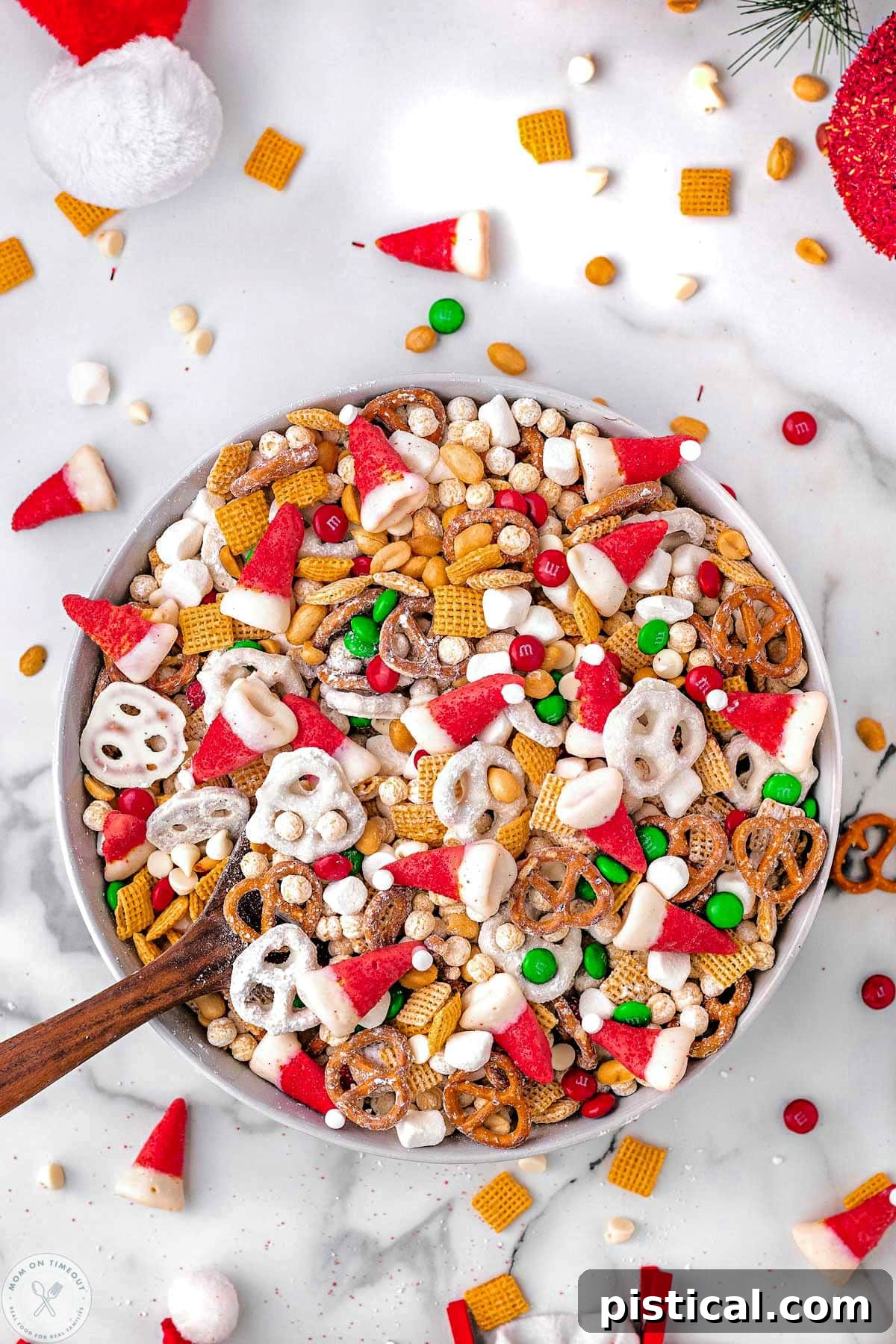 Overhead shot of a large bowl filled with Santa's Holiday Snack Mix, showcasing the vibrant colors and varied textures of all the festive ingredients.