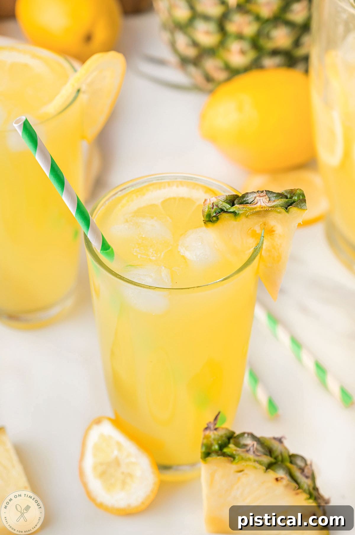 Glass of pineapple lemonade with a pineapple wedge garnish on rim.