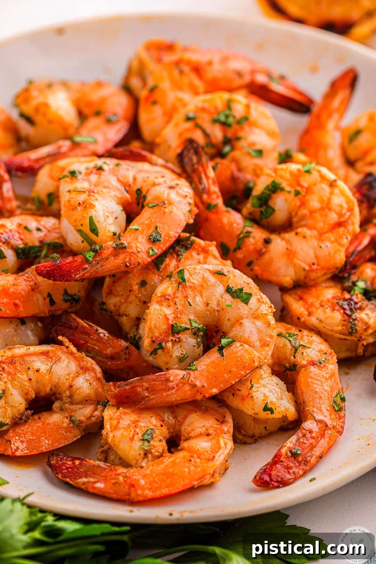 Close up of white dinner plate piled high with cajun shrimp.
