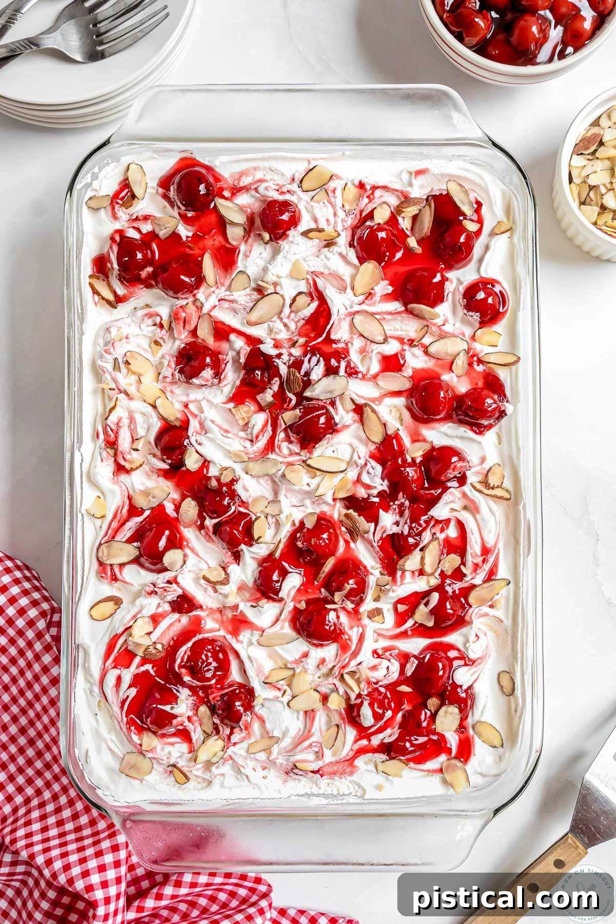 Overhead shot of cherry Heaven On Earth Cake in a 9 x 13 glass dish topped with sliced almonds.