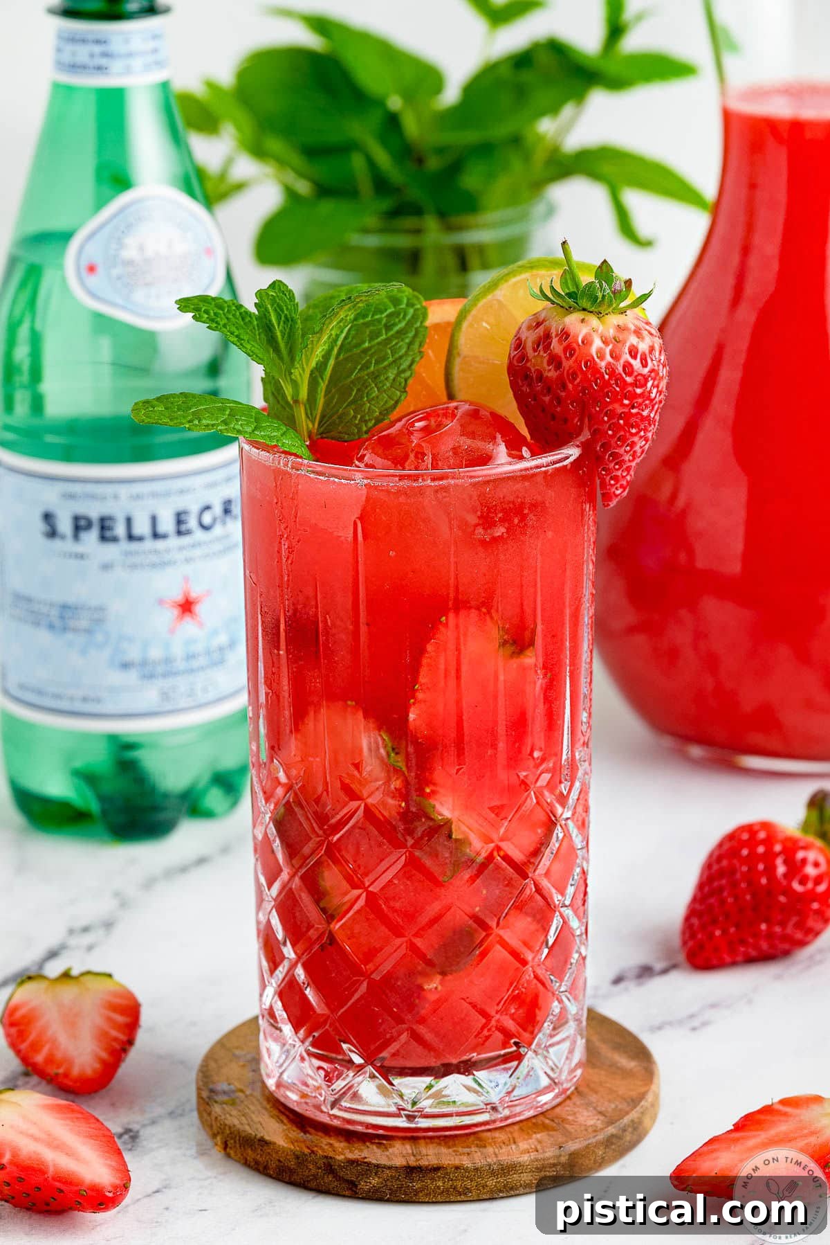 Fresh Strawberry Mojito Recipe: Sparkling Summer Cocktail 3 Strawberry Mojito mocktail with a glass of sparkling water in the background.