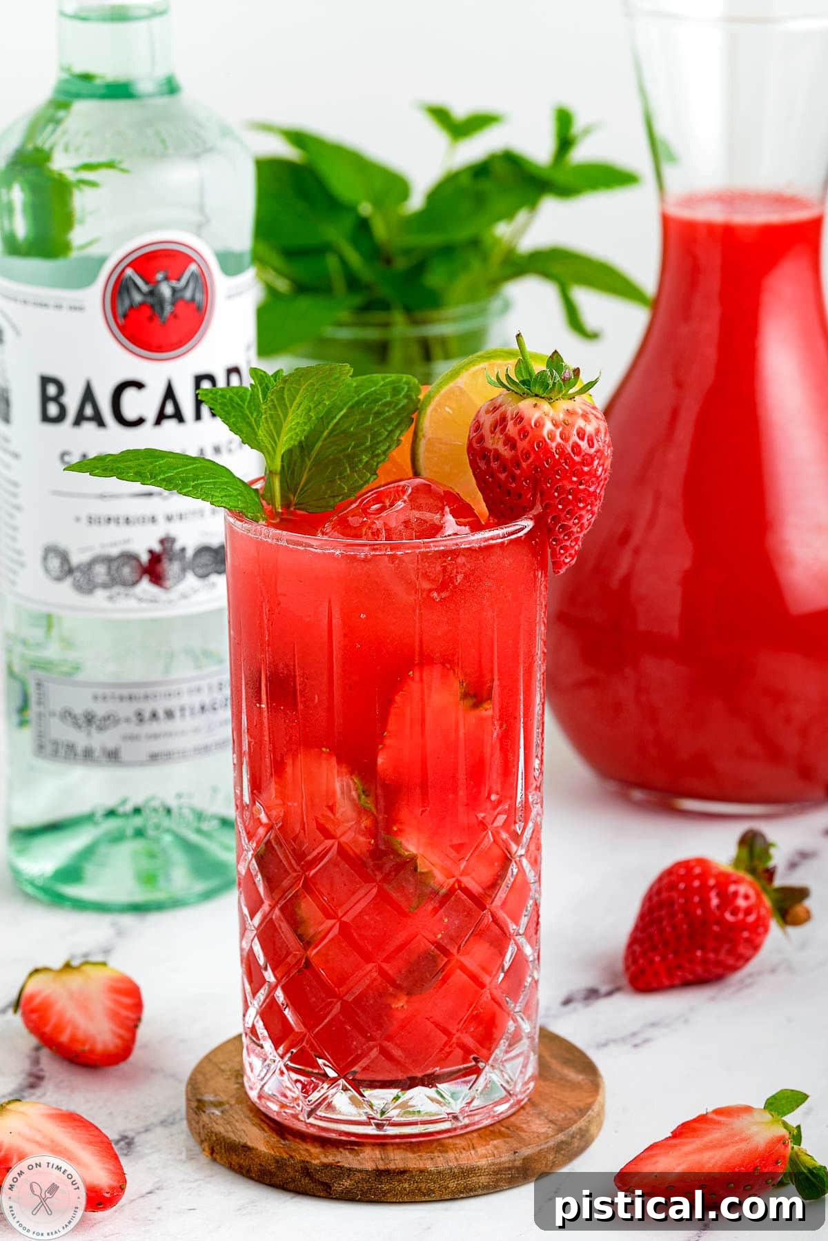 Fresh Strawberry Mojito Recipe: Sparkling Summer Cocktail 6 Strawberry Mojito with a bottle of rum in the background.