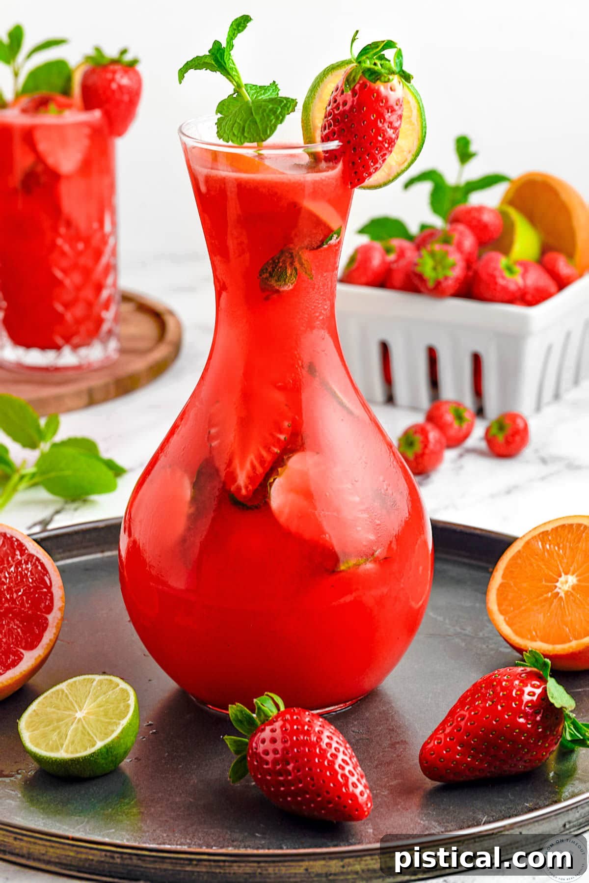Fresh Strawberry Mojito Recipe: Sparkling Summer Cocktail 7 Tall glass pitcher filled with strawberry mojito recipe and garnished with fresh mint and strawberries.